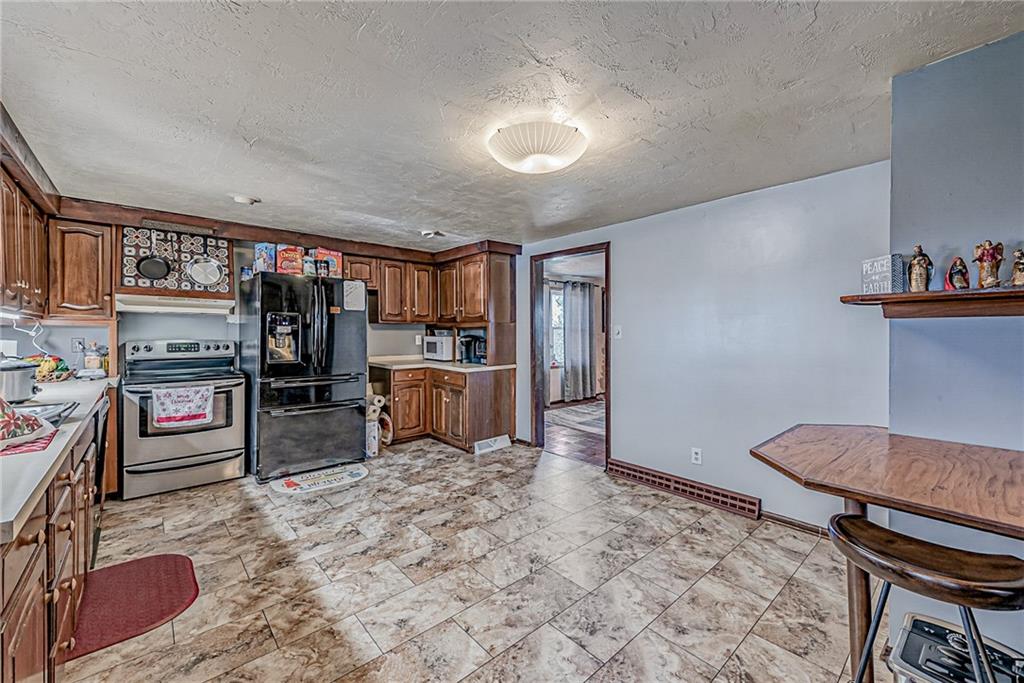 632 Hopewell Road White, PA 15490 - Photo 11 of 25 a view of a kitchen with refrigerator stove and wooden floor