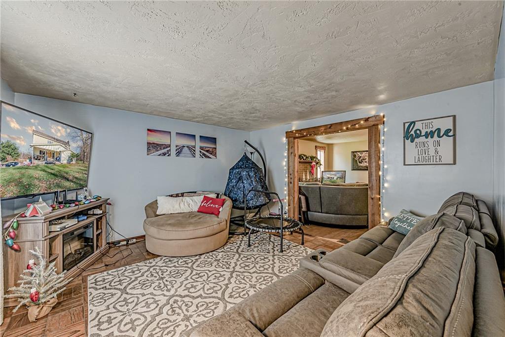 632 Hopewell Road White, PA 15490 - Photo 6 of 25 a living room with furniture a flat screen tv and a floor to ceiling window