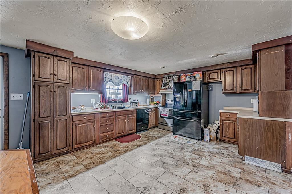 632 Hopewell Road White, PA 15490 - Photo 8 of 25 a kitchen with stainless steel appliances granite countertop a refrigerator stove top oven and sink