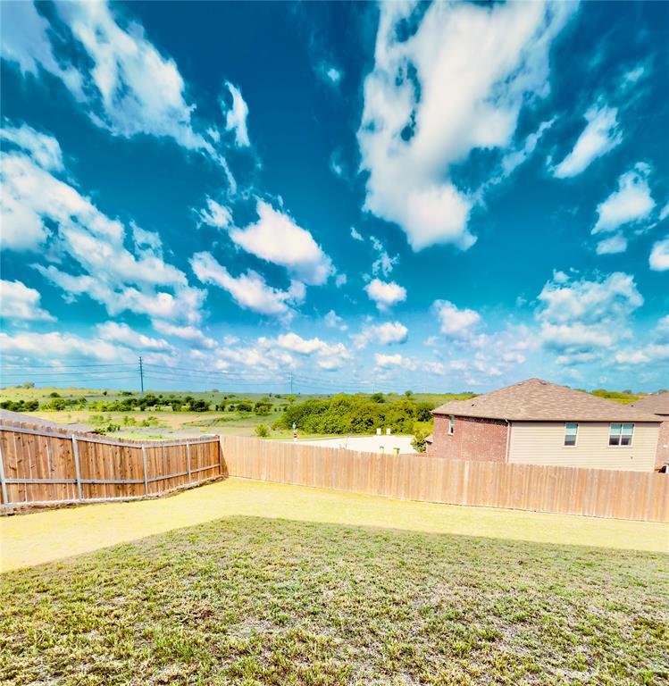 196 Cattlemans Crk Road West Newark, TX 76071 - Photo 19 of 24 Expansive backyard featuring a partial wooden privacy fence and a sloped, grassed area