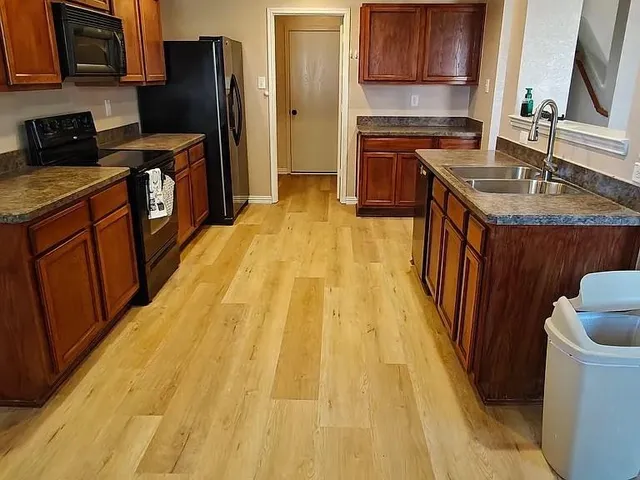 a kitchen with a sink appliances and cabinets