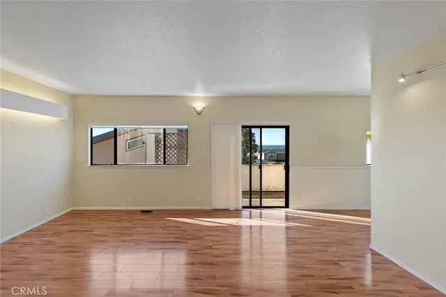 a view of a big room with wooden floor and windows