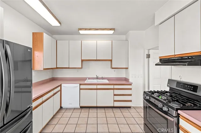 a kitchen with a refrigerator and white cabinets