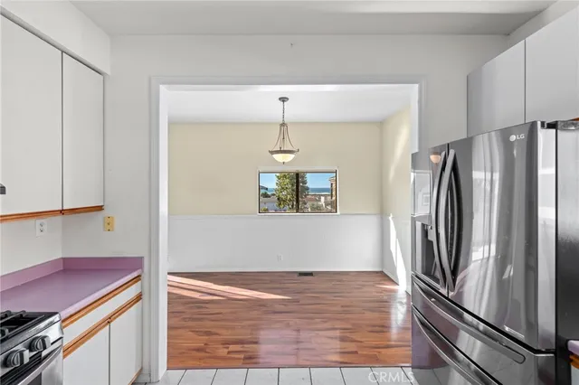 a kitchen with stainless steel appliances granite countertop a stove and a white cabinets