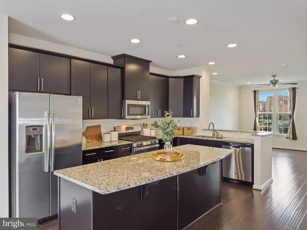 a kitchen with stainless steel appliances granite countertop a sink a stove and a refrigerator