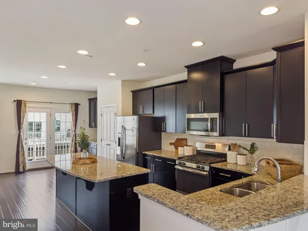 a kitchen with granite countertop appliances a sink and a counter top space