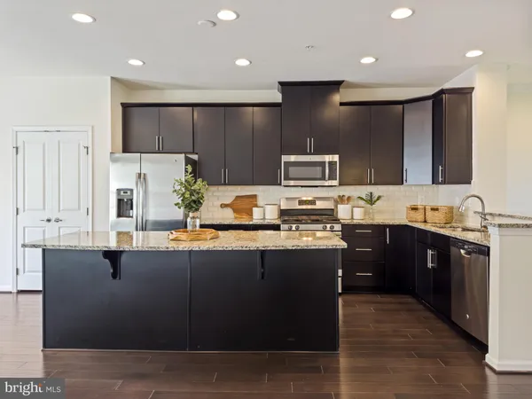 a kitchen with kitchen island granite countertop stainless steel appliances and sink