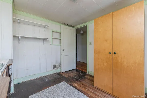 a view of a room with an empty space and wooden floor
