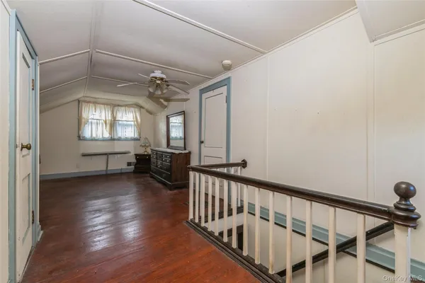 a view of a hallway with wooden floor and windows