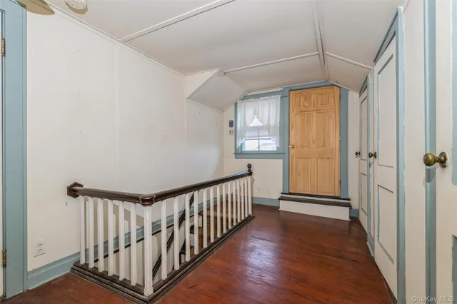 a view of a hallway with wooden floor and a window