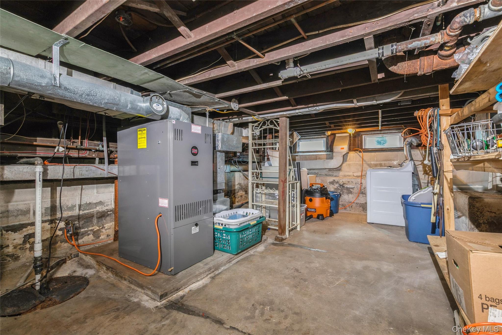 84 Riviera Drive Mastic, NY 11950 - Photo 21 of 28 Unfinished basement with washer / dryer, heating unit, and drainage system