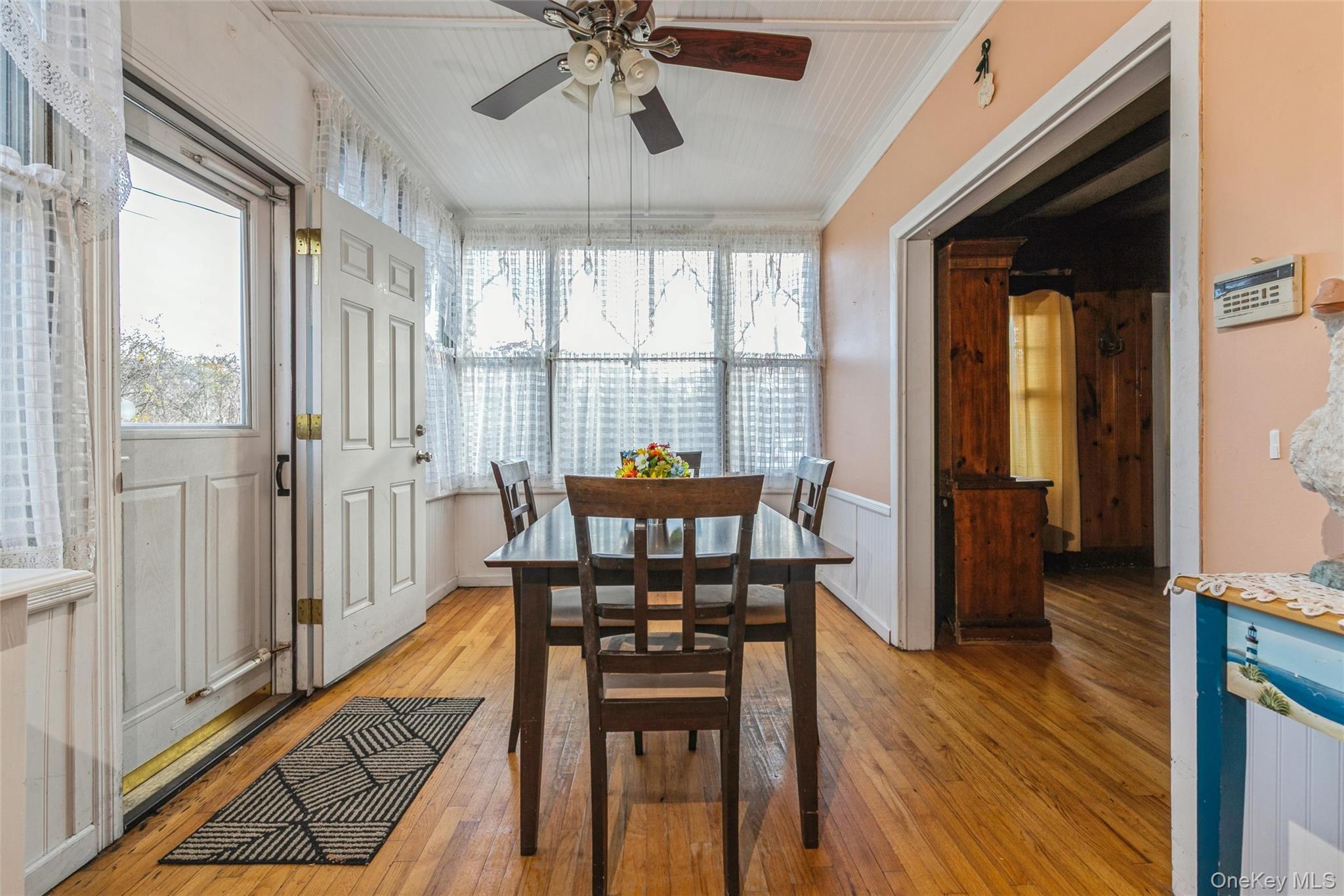 84 Riviera Drive Mastic, NY 11950 - Photo 3 of 28 Dining space featuring light wood-style flooring, ornamental molding, wainscoting, and ceiling fan