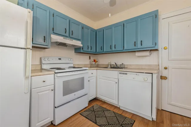a kitchen with granite countertop cabinets and white appliances