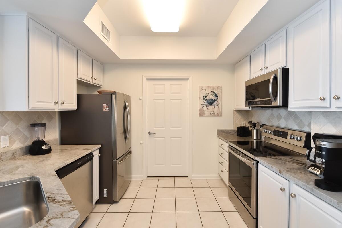 1050 Highway 98, Unit 905E Destin, FL 32541 - Photo 9 of 30 a kitchen with a sink a stove and refrigerator