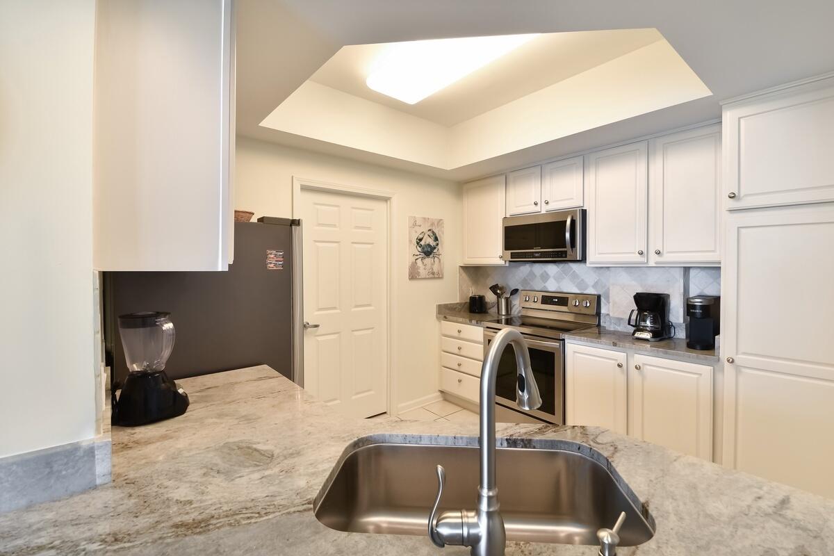 1050 Highway 98, Unit 905E Destin, FL 32541 - Photo 10 of 30 a kitchen that has a sink and a stove with wooden floor
