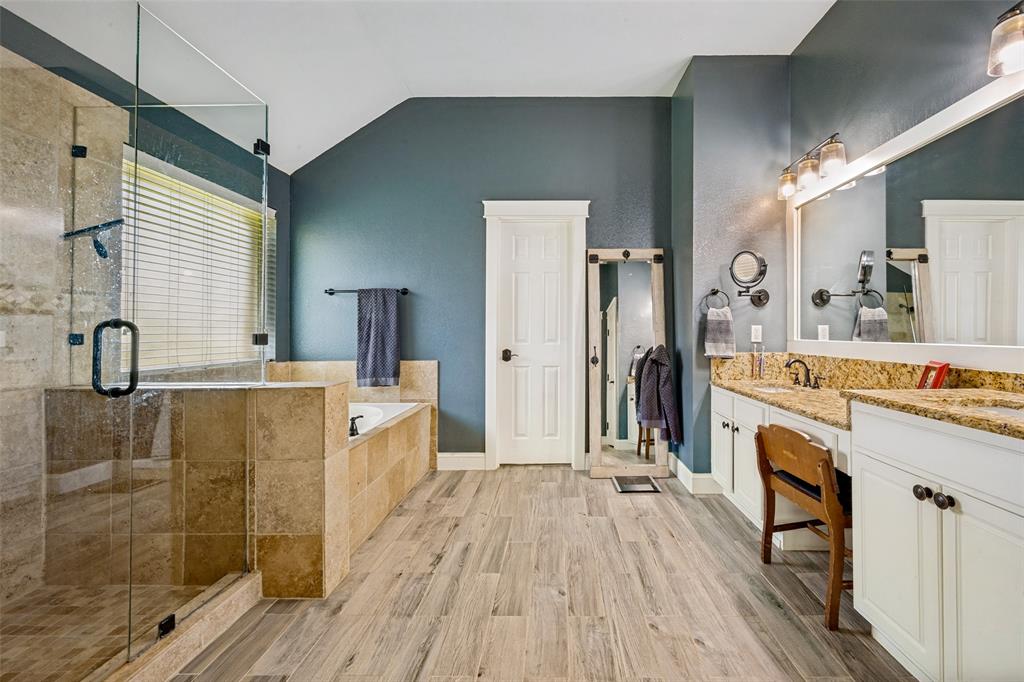 3105 Union Lake Road Denton, TX 76210 - Photo 19 of 27 Spacious bathroom featuring a glass-enclosed shower, a separate soaking tub with tiled surround, and wood-finish flooring