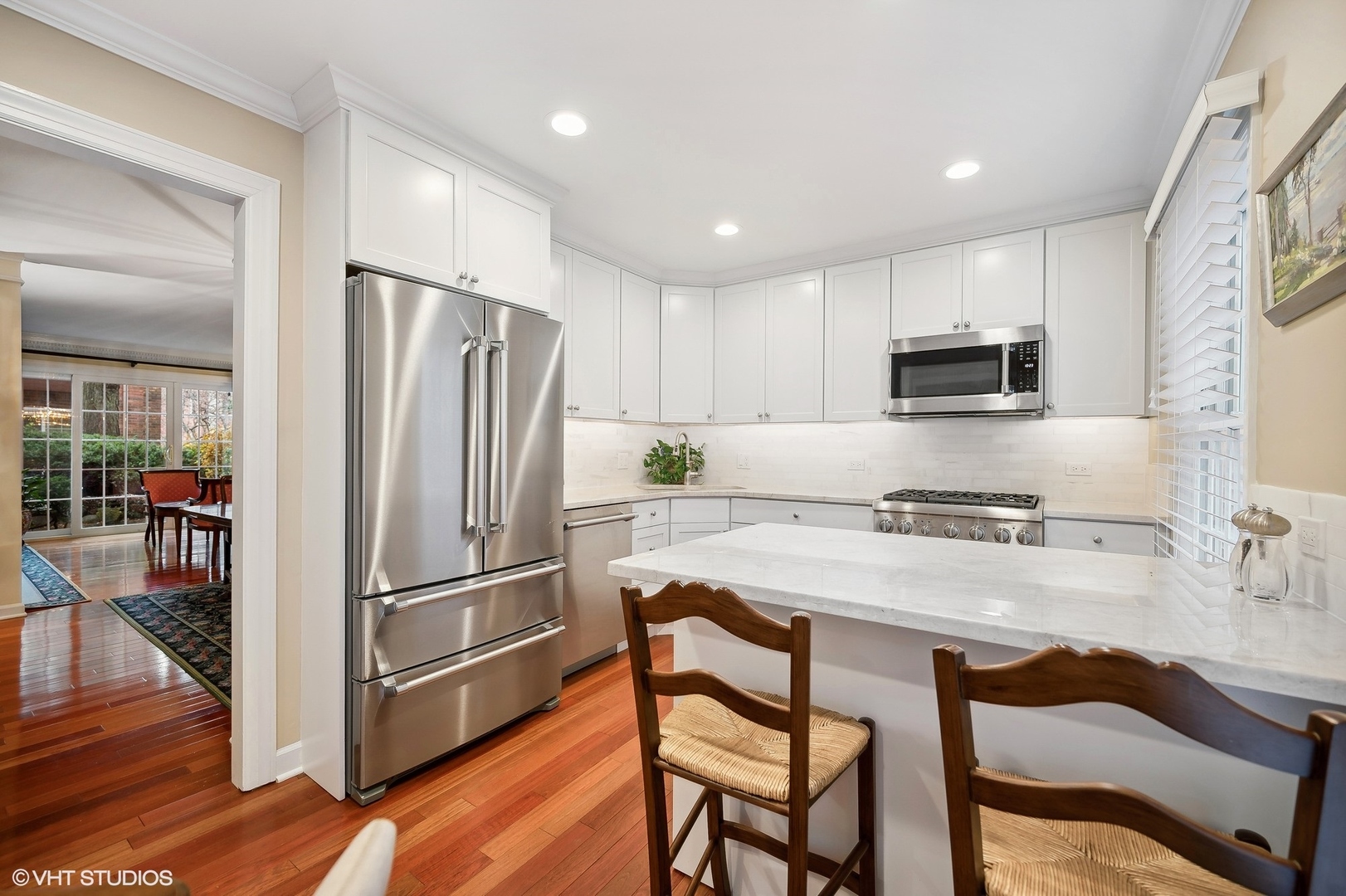 3 Landmark Street Northfield, IL 60093 - Photo 15 of 31 a kitchen with stainless steel appliances granite countertop a refrigerator a stove a sink a dining table and chairs with wooden floor