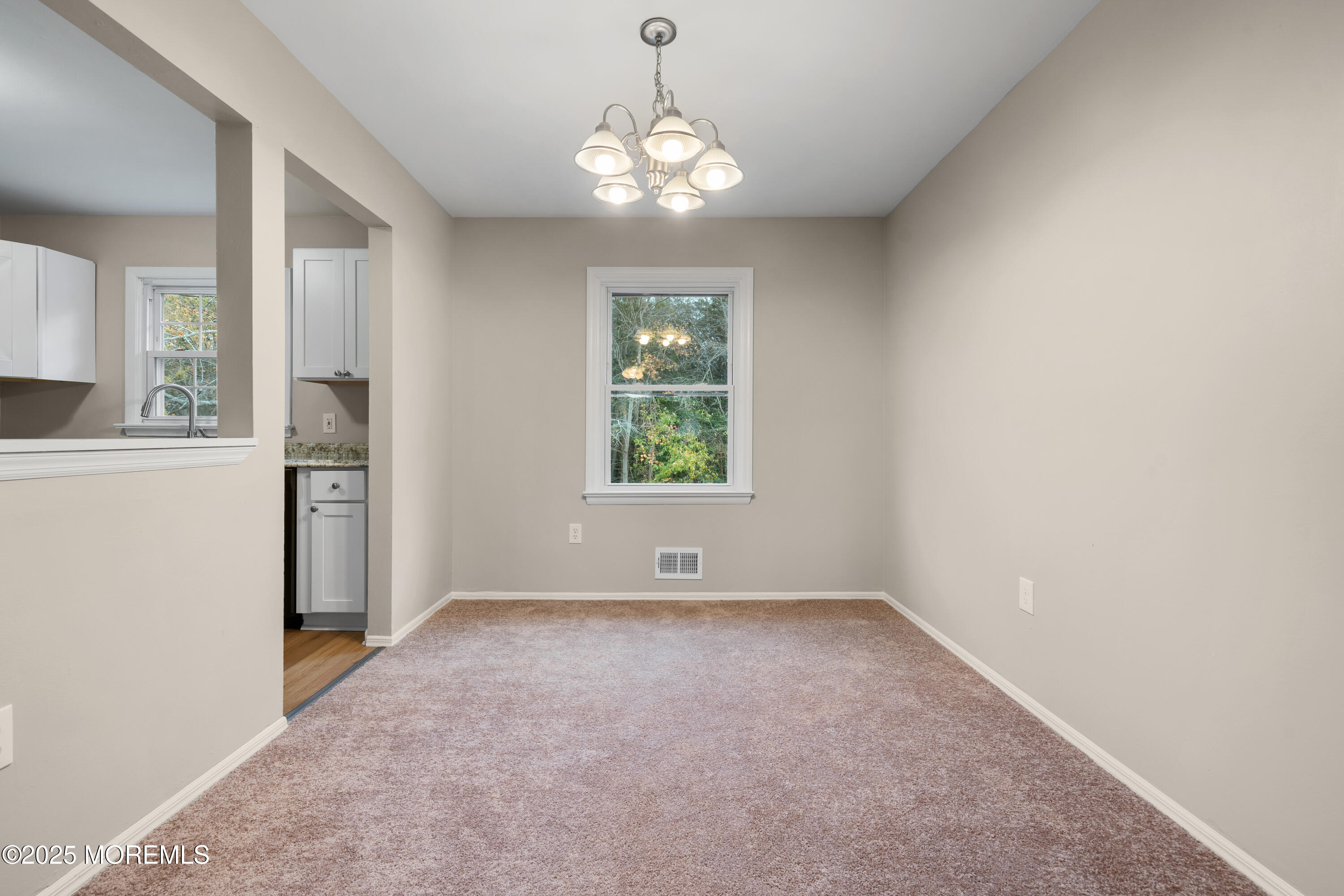 137 Red Bank Avenue Bayville, NJ 08721 - Photo 13 of 24 an empty room with windows and chandelier