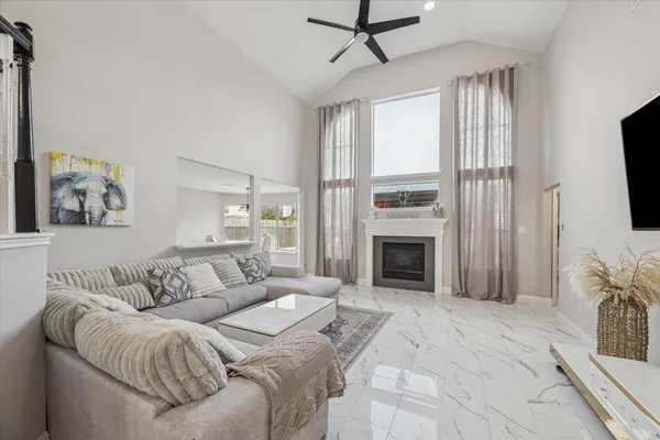 a living room with furniture a fireplace and a flat screen tv