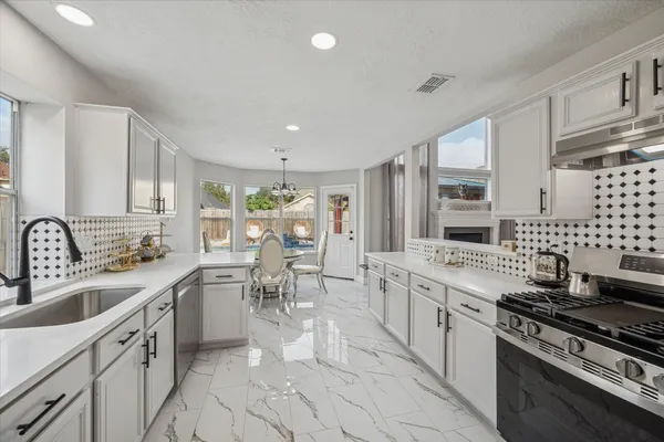 a kitchen with stove a sink and cabinets