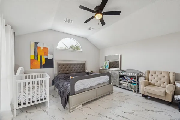 a bedroom with a large bed and a couch