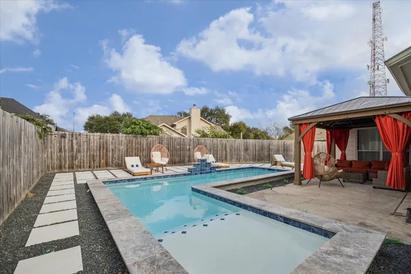 a view of a house with pool and sitting area