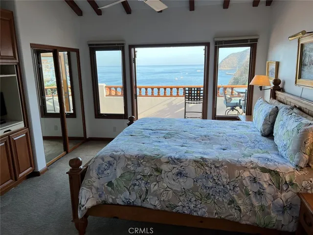 a bedroom with a bed and a lamp on dresser