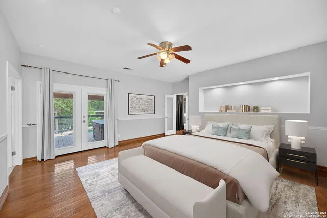 a spacious bedroom with a large bed and a chandelier