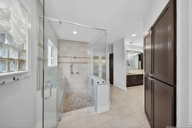 a bathroom with a glass shower door and a mirror