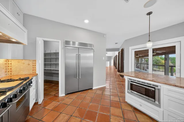 a kitchen with granite countertop a stove and a refrigerator