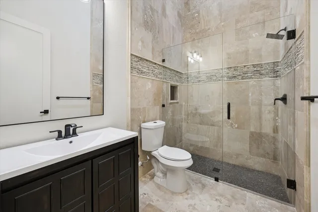 a bathroom with a sink toilet a mirror and shower