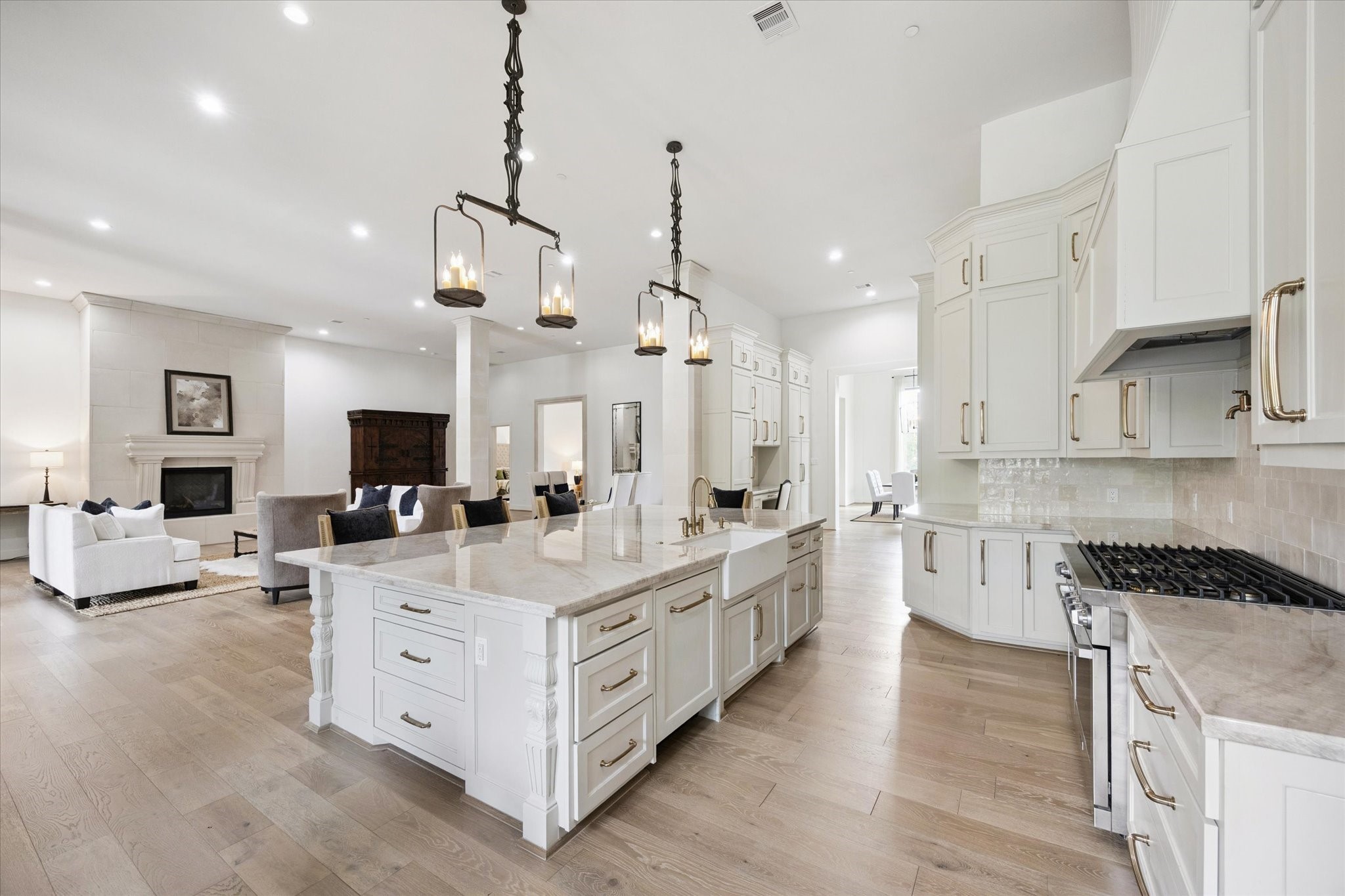 11 River Circle Houston, TX 77063 - Photo 6 of 34 a large kitchen with kitchen island a stove a sink a center island and a wooden floor
