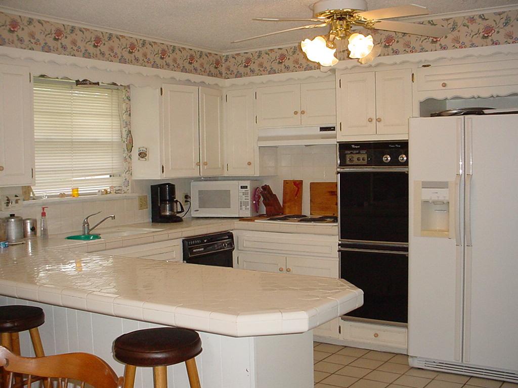 6200 Dreyfuss Road Amarillo, TX 79106 - Photo 4 of 7 a kitchen with stainless steel appliances kitchen island granite countertop a refrigerator a sink dishwasher and white cabinets next to a window
