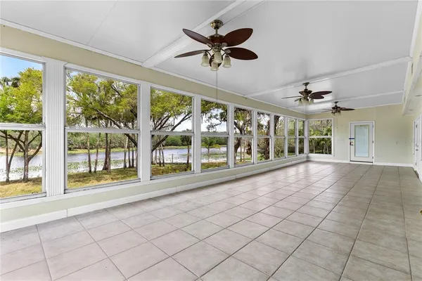 a view of an empty room with a floor to ceiling windows and a ceiling fan