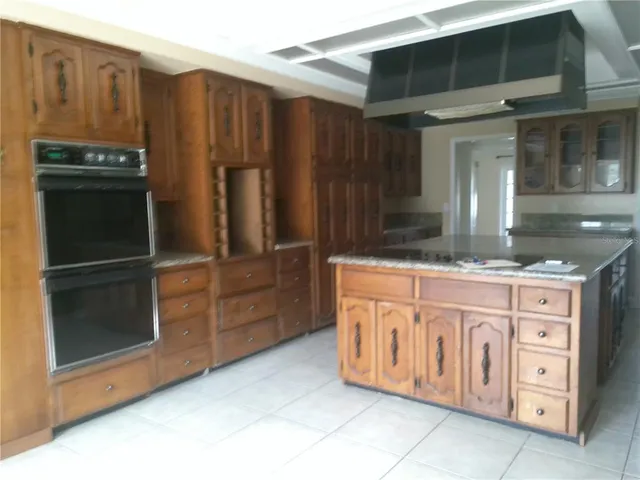 a kitchen with granite countertop a refrigerator and cabinets