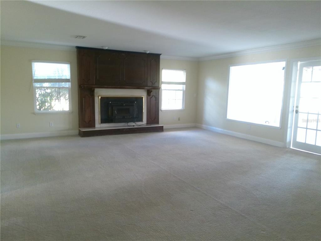 3821 East Osceola Road Geneva, FL 32732 - Photo 18 of 37 an empty room with a fireplace and windows