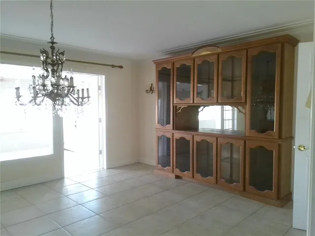 a view of a livingroom with kitchen and chandelier