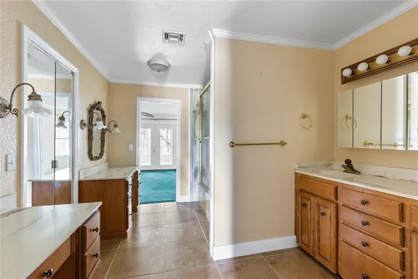 a en suite bathroom with a granite countertop sink and a mirror