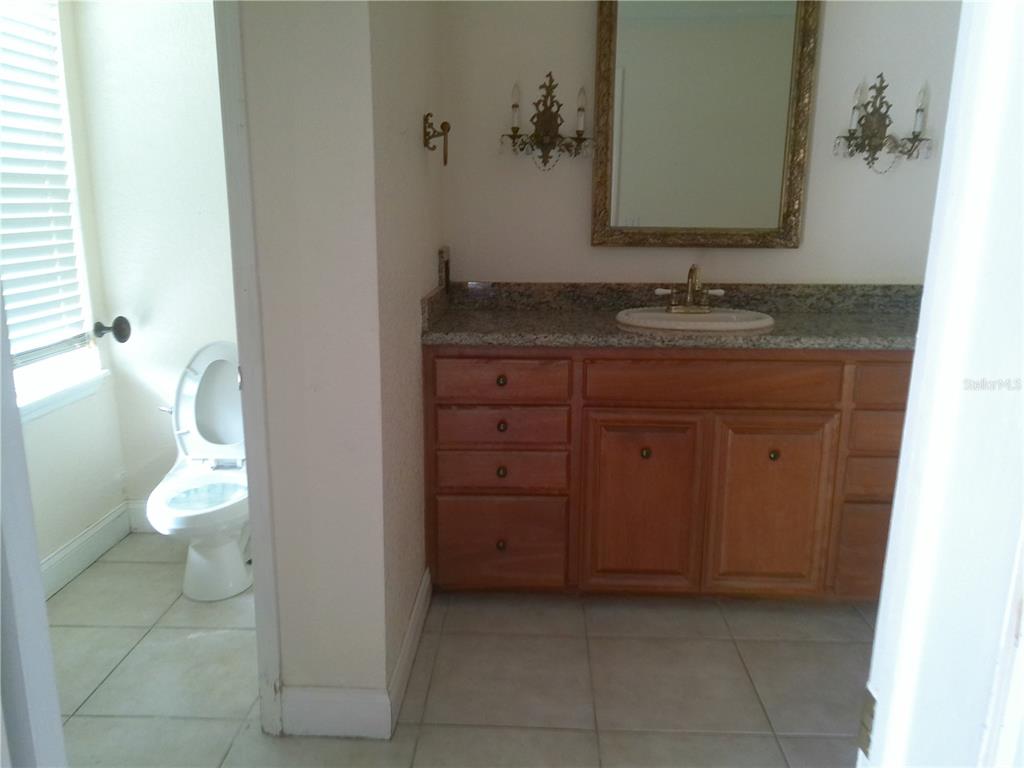 3821 East Osceola Road Geneva, FL 32732 - Photo 29 of 37 a bathroom with a granite countertop sink and a toilet