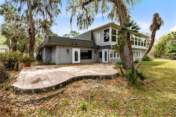 a view of a white house with a yard and potted plants