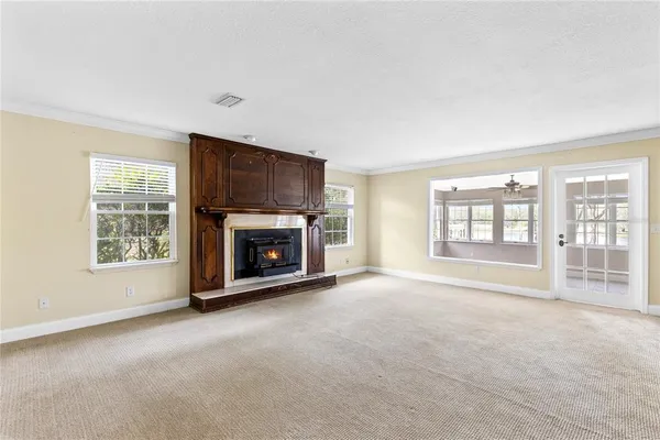 a view of an empty room with a fireplace and a window