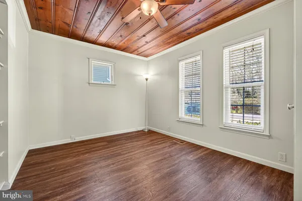 a view of empty room with wooden floor