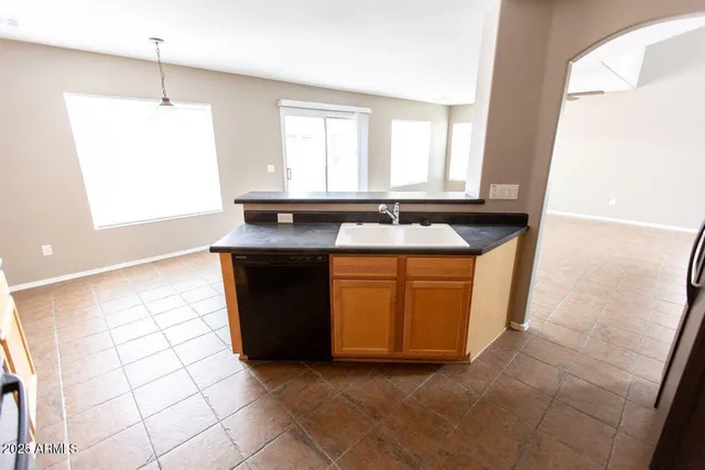 a kitchen with granite countertop a sink a stove a microwave and cabinets