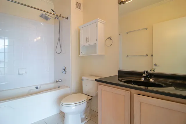 a bathroom with a granite countertop sink a toilet and shower