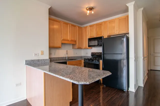a kitchen with stainless steel appliances granite countertop a sink refrigerator and microwave