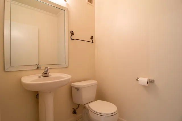 a bathroom with a sink a toilet and mirror
