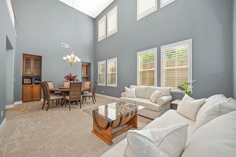 a living room with furniture and a dining table