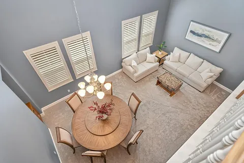 a dining room with furniture a large window and wooden floor