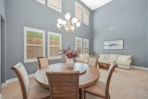 a kitchen with stainless steel appliances granite countertop a kitchen island hardwood floor sink stove dining table and chairs