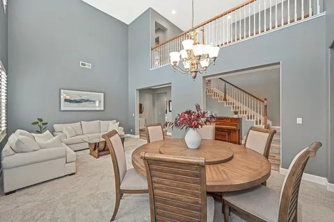 a kitchen with stainless steel appliances granite countertop a dining table chairs and granite counter tops